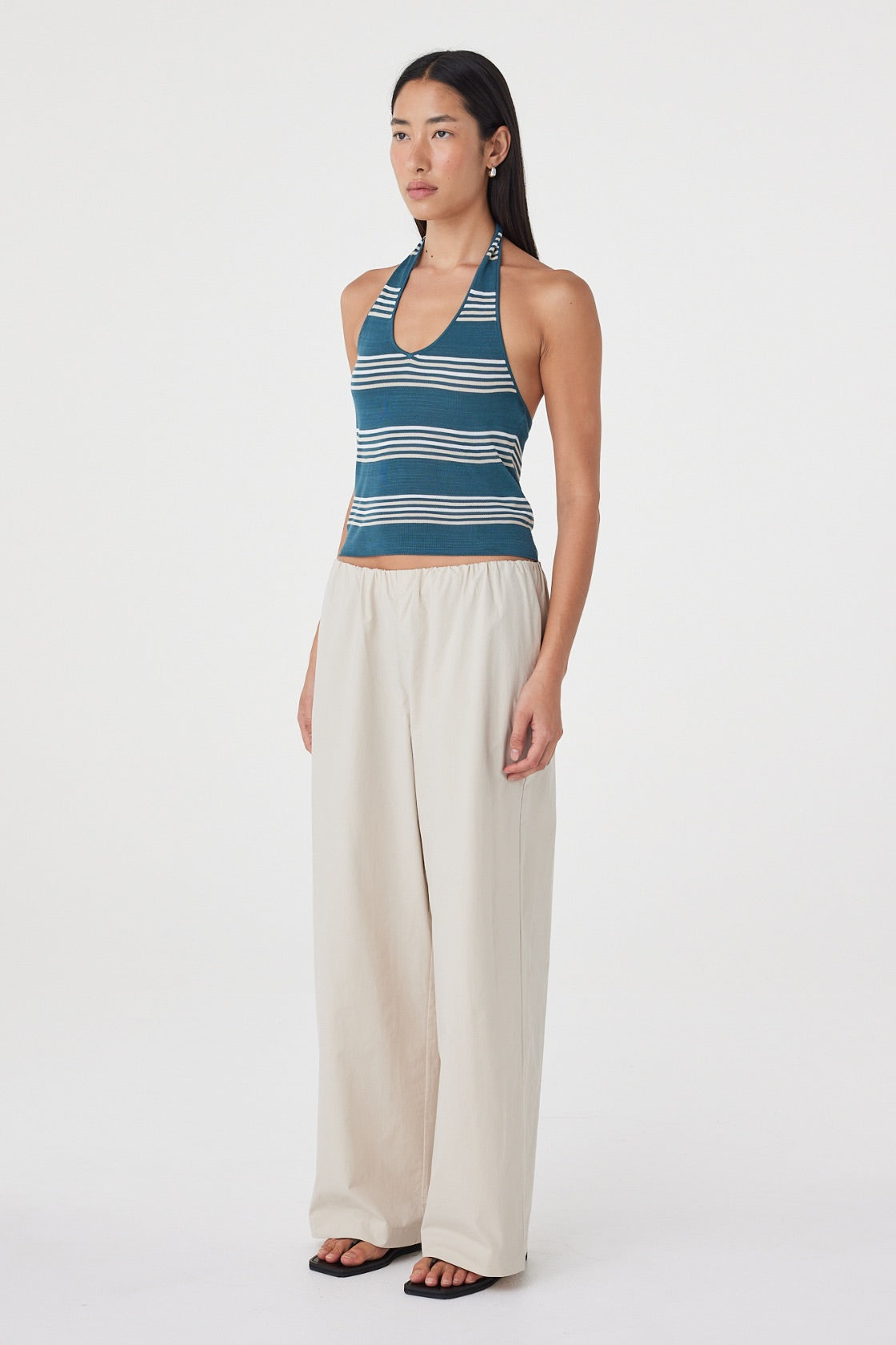 Side view of the Annika Pant in Taupe paired with a striped tank, showing the relaxed fit through the waist and hip.