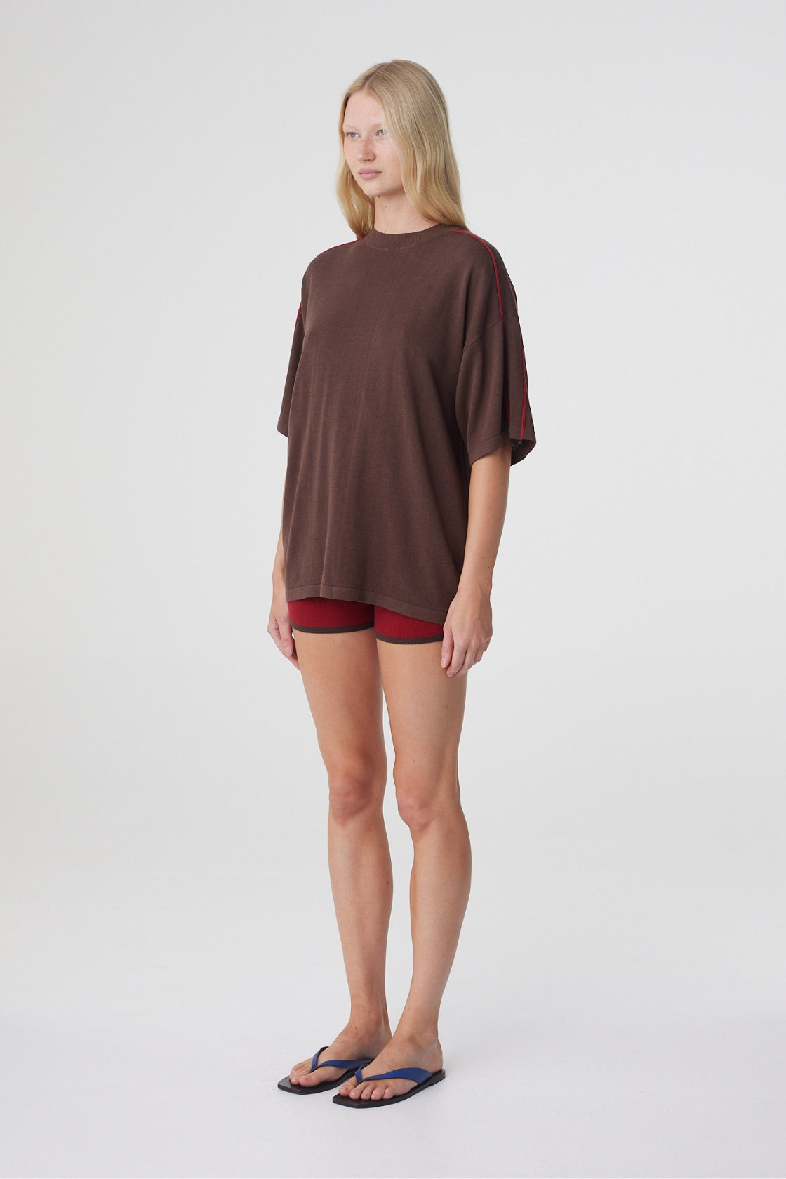 Tove Short in Chilli, three quarter view styled with an oversized espresso tee, showing the short length and close fit.