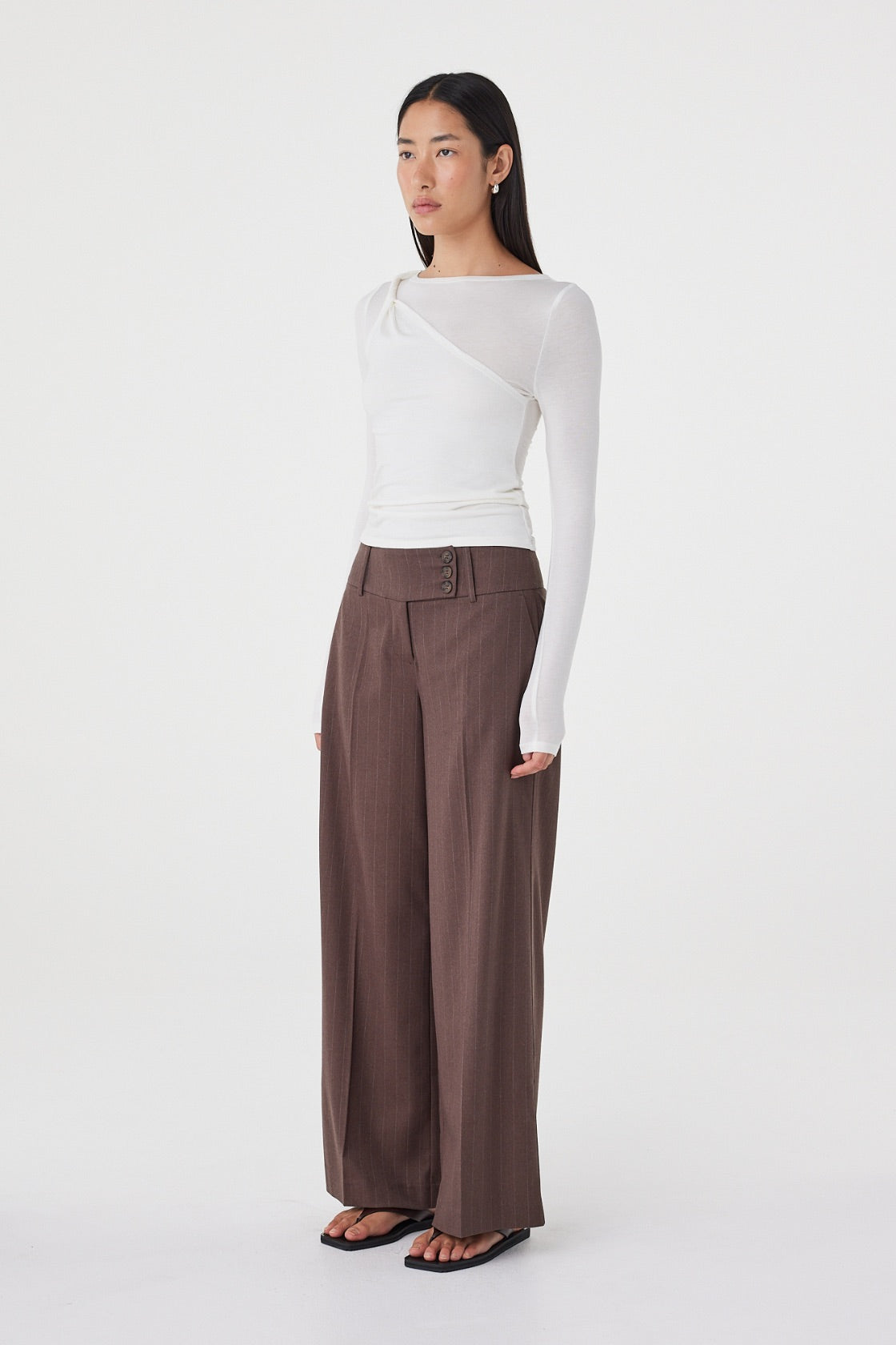 Side view of the Mabel LS Twist Top in Cream featuring the front shoulder twist detail, slim fit and clean profile.
