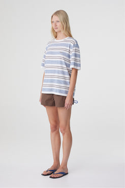 Noor Tee in White & Blue Retro Stripe, three quarter view showing the short sleeves, ribbed crew neckline and custom blue stripe pattern.