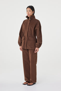 Side profile of the Amari Jacket in espresso featuring oversized sleeves, elasticated waist shaping and a soft velvet finish through the cotton fabric