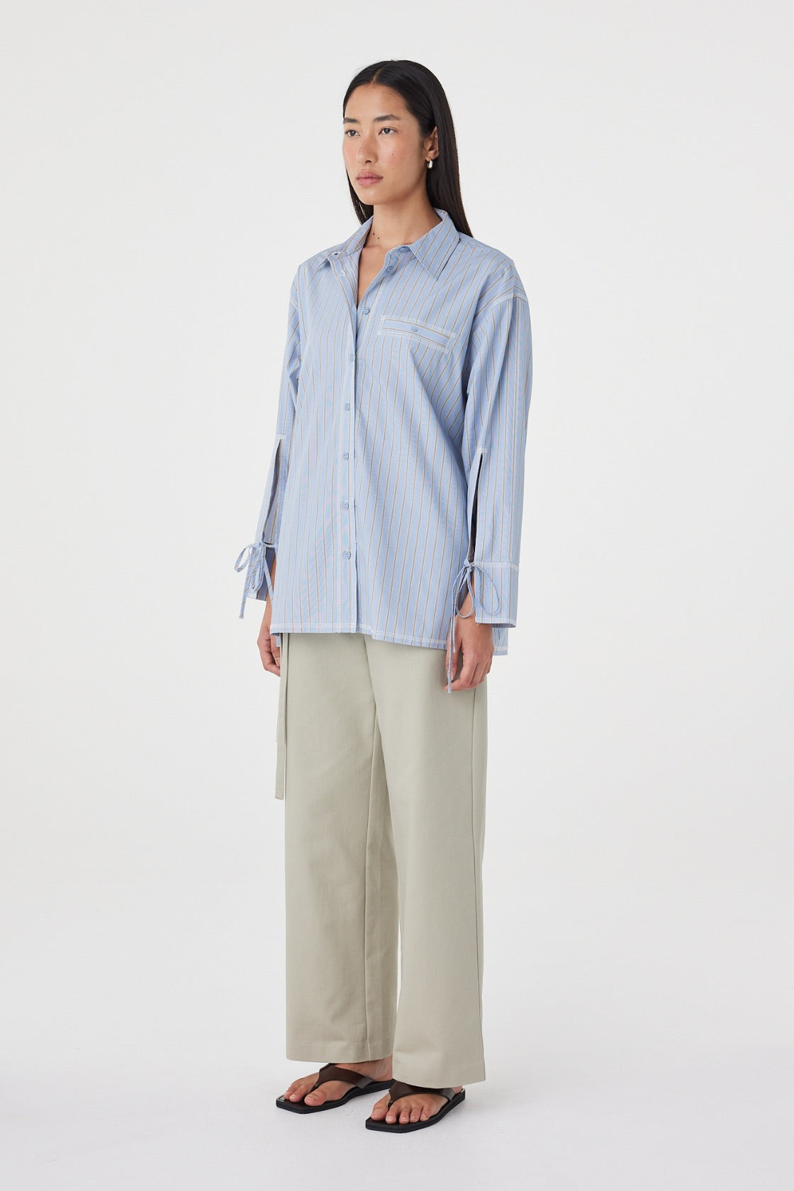 Side view of the Blair Shirt in Blue Taupe Stripe featuring the relaxed off-body fit, adjustable cuff ties and soft cotton fabrication.