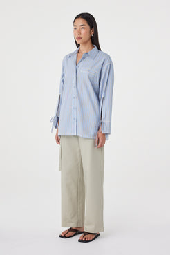 Side view of the Blair Shirt in Blue Taupe Stripe featuring the relaxed off-body fit, adjustable cuff ties and soft cotton fabrication.