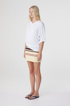 Mara Mini Skirt in Butter Espresso Stripe, three quarter view styled with a relaxed white tee and flat sandals.