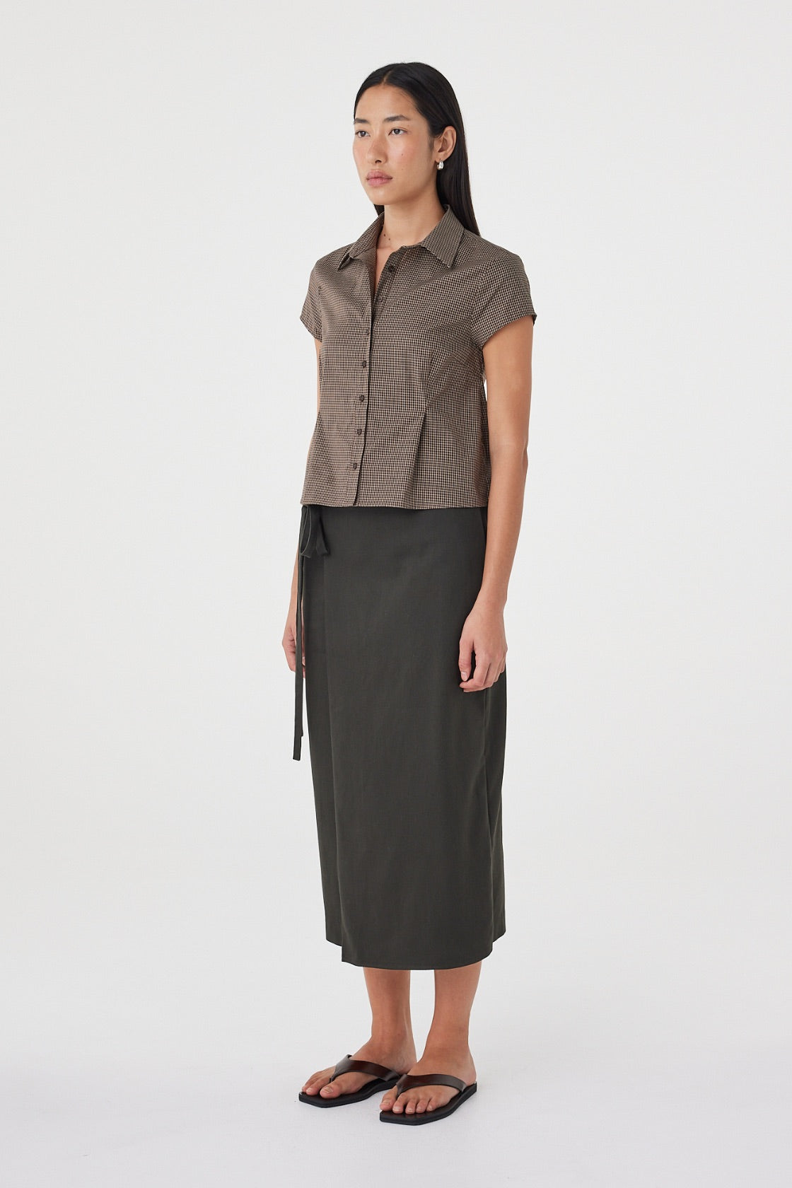Side view of the Freya Shirt in Chocolate Check featuring the slim silhouette, cap sleeves and lightweight cotton fabrication.

