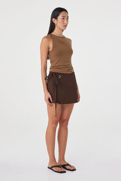 Angled view of the Mable Tank in Deep Cedar showing the asymmetric neckline, subtle gathering and close fit through the body.
