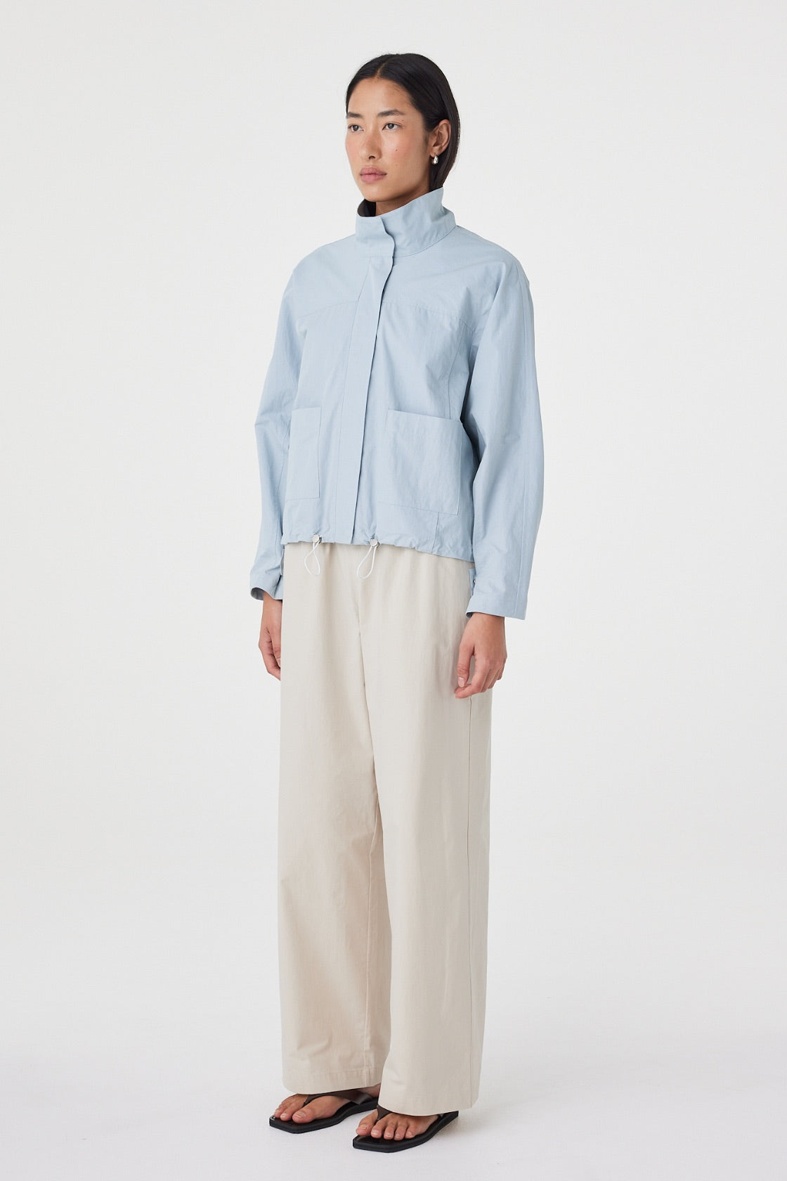 Side view of the Addie Jacket in Pale Blue showcasing the easy layered fit, clean silhouette and adjustable hem.