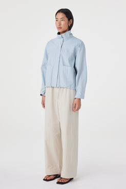 Side view of the Addie Jacket in Pale Blue showcasing the easy layered fit, clean silhouette and adjustable hem.