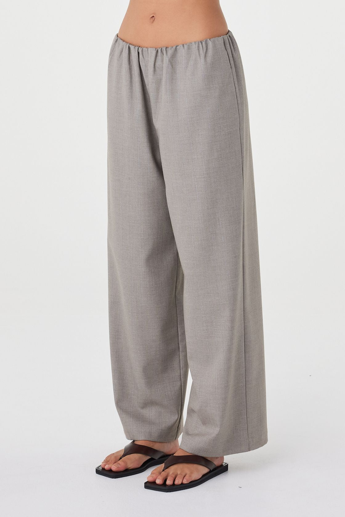 Close-up angled view of the Annika Pant in taupe blue pinstripe highlighting the fluid drape, relaxed fit through the leg and subtle vertical pinstripe texture