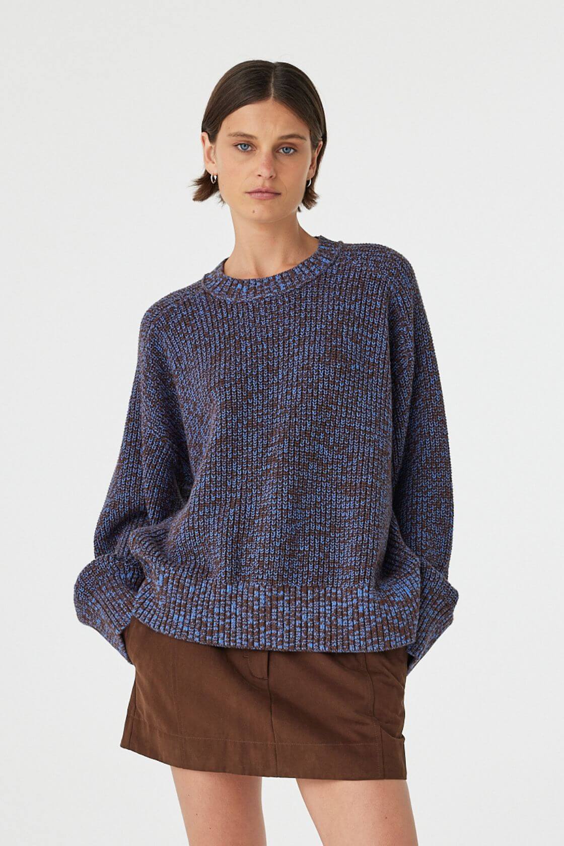 Solene sweater in chocolate and royal blue worn slightly angled, highlighting the chunky knit texture, ribbed cuffs and oversized drape through the body