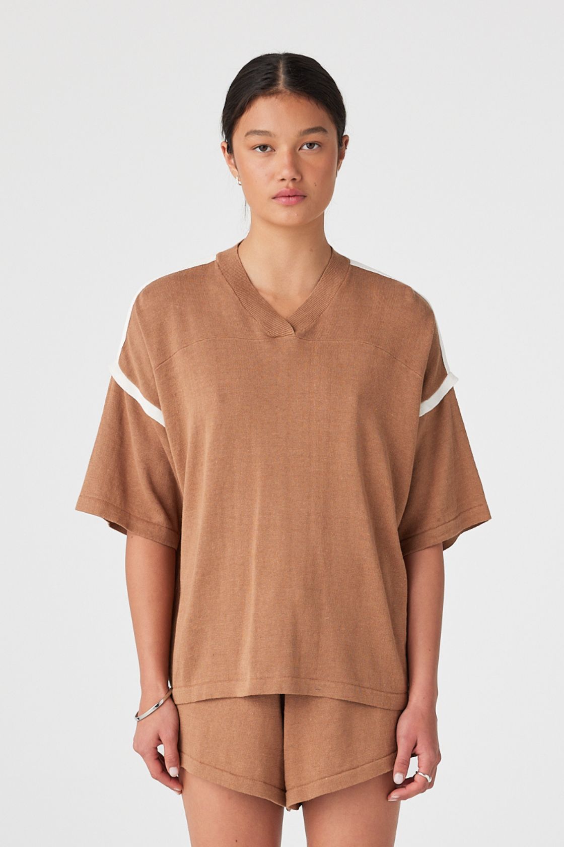 Model wears oversized linen-blend tee in pecan with cream contrast shoulder stripe and ribbed V-neck