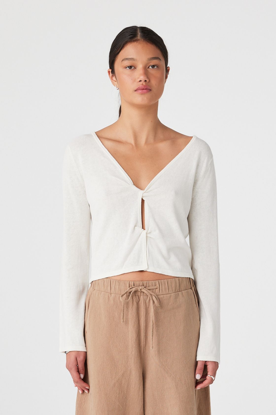 Linen–cotton top worn with twist cut-out at front and scoop neckline, styled with relaxed trousers