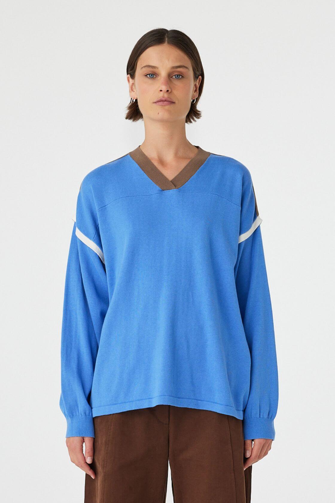 Eden long sleeve tee in royal blue and espresso worn front on, featuring an oversized slouchy fit, ribbed V-neckline and contrast shoulder detailing, styled with brown trousers