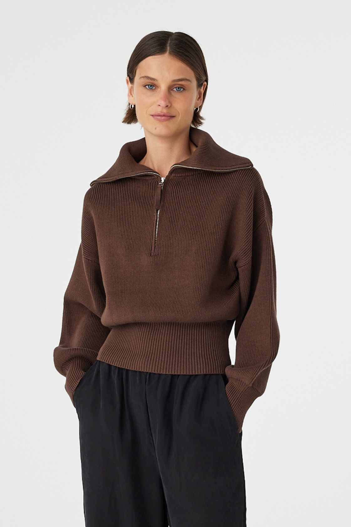 Marely zip sweater in espresso worn at an angle, showing the relaxed drape through the body and fitted hemline, styled with black pants and sandals