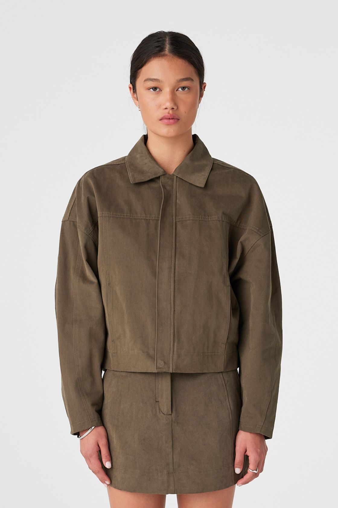 Front view of khaki velvet-finish cotton jacket showing concealed zip closure and cropped hem
