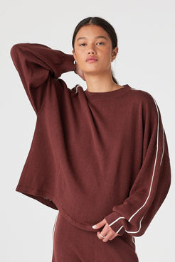 Model wearing Raisin oversized long sleeve knit tee with cream contrast stripe, drop shoulder fit for cool evenings and travel