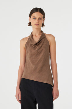 Model wearing Alessia Top in choc polka dot, cotton halter cowl neck top with low back and asym hem, close front view.