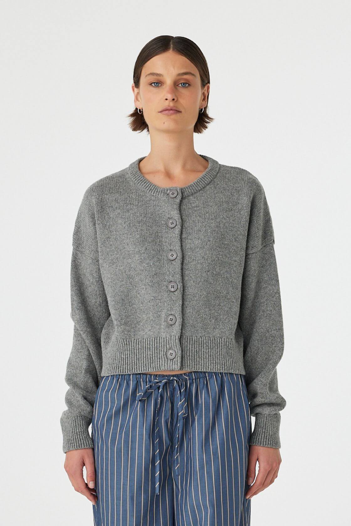 Model wearing Bobby Cardigan in grey marle, relaxed crew-neck cotton-blend knit with button front and ribbed hem, front view.