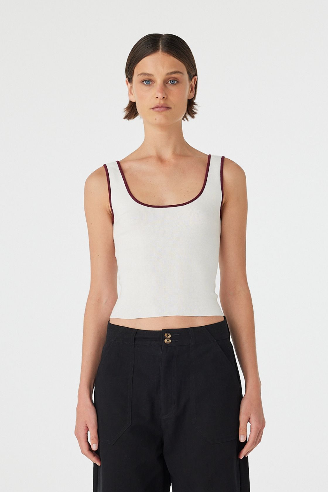 Model wearing Kaya Tank in cream with merlot contrast trim, slim-fit organic cotton knit tank, front close view.