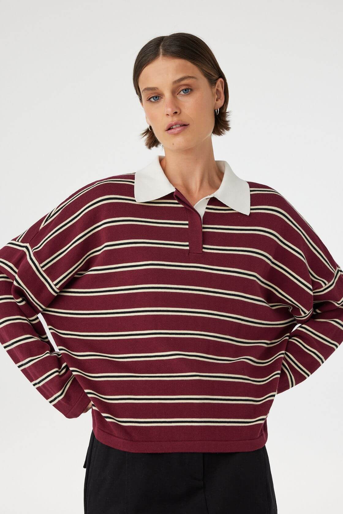 Model wearing Rayne Knit Jersey in merlot stripe, oversized organic cotton polo knit with contrast collar, close front view.