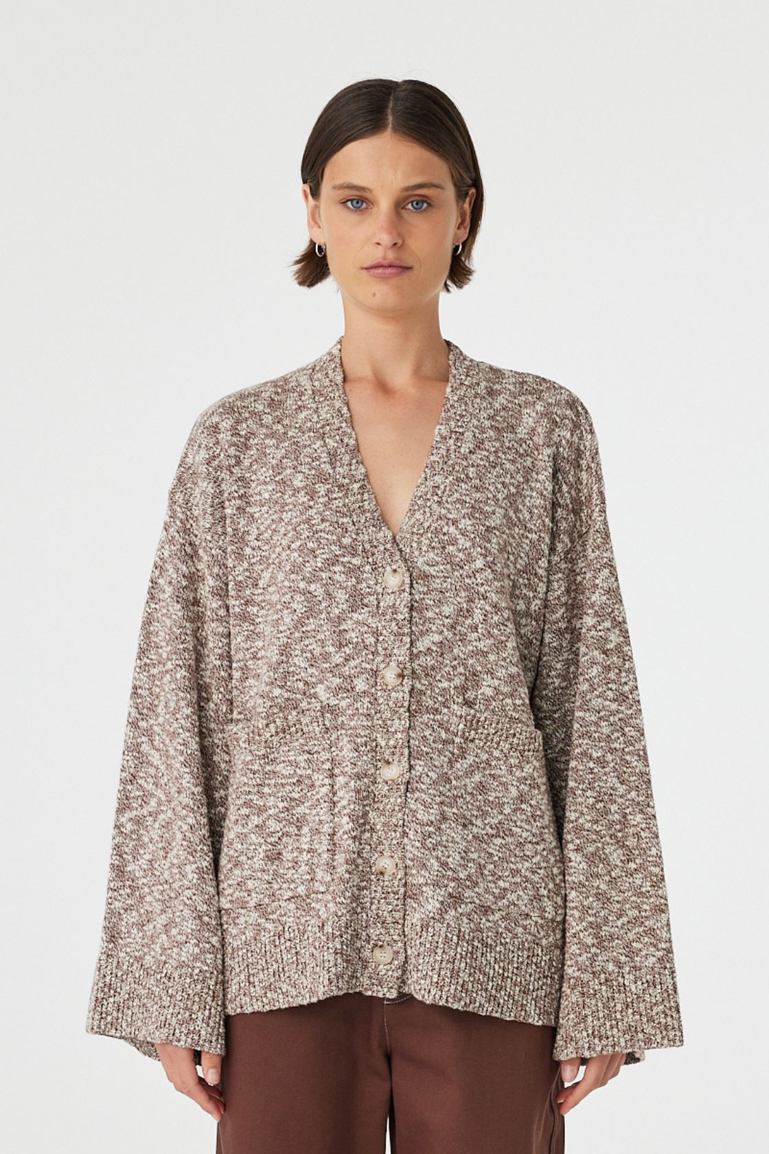 Emmet cardigan in chocolate and cream worn front on, showcasing the longline relaxed fit, textured slub knit and centre front button closure, styled with matching knit pants 