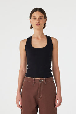 Full body front view of Sable Top black, racerback knit tank styled with brown pants.