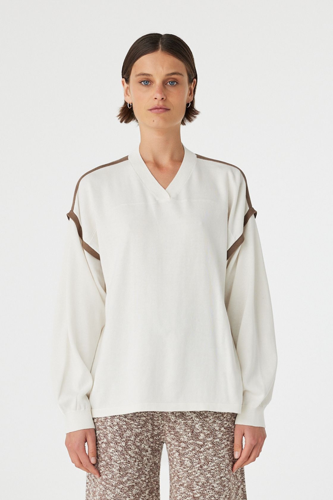 Close up of Eden long sleeve tee in cream and espresso worn front on, featuring an oversized slouchy fit, ribbed V-neckline and contrast shoulder detailing, styled with marled wide leg pants