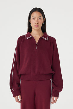 Front close-up view of the Nella Zip in merlot and cream featuring contrast piping along the collar and sleeves, a silver 1/4 zip closure and ribbed waistband detail styled with matching knit pants