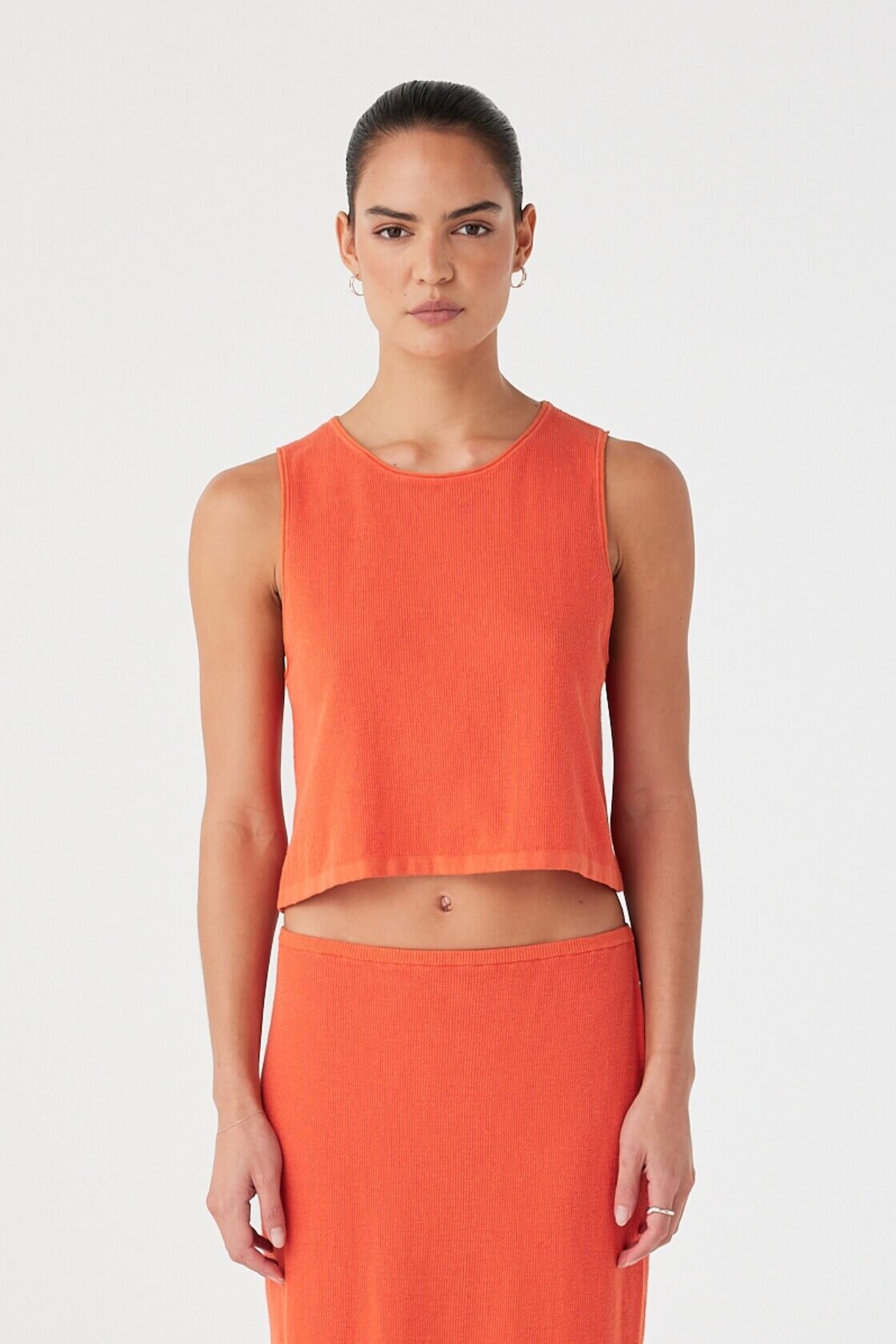 Model in mandarin rib knit tank made from organic cotton hemp blend, with relaxed fit and rolled edges.