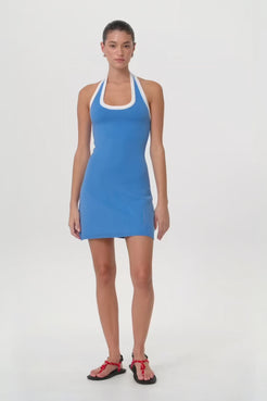 Model in motion wearing pacific blue halter mini dress, highlighting fluid fit, stretch comfort, and breathable knit for warm-weather transitions.