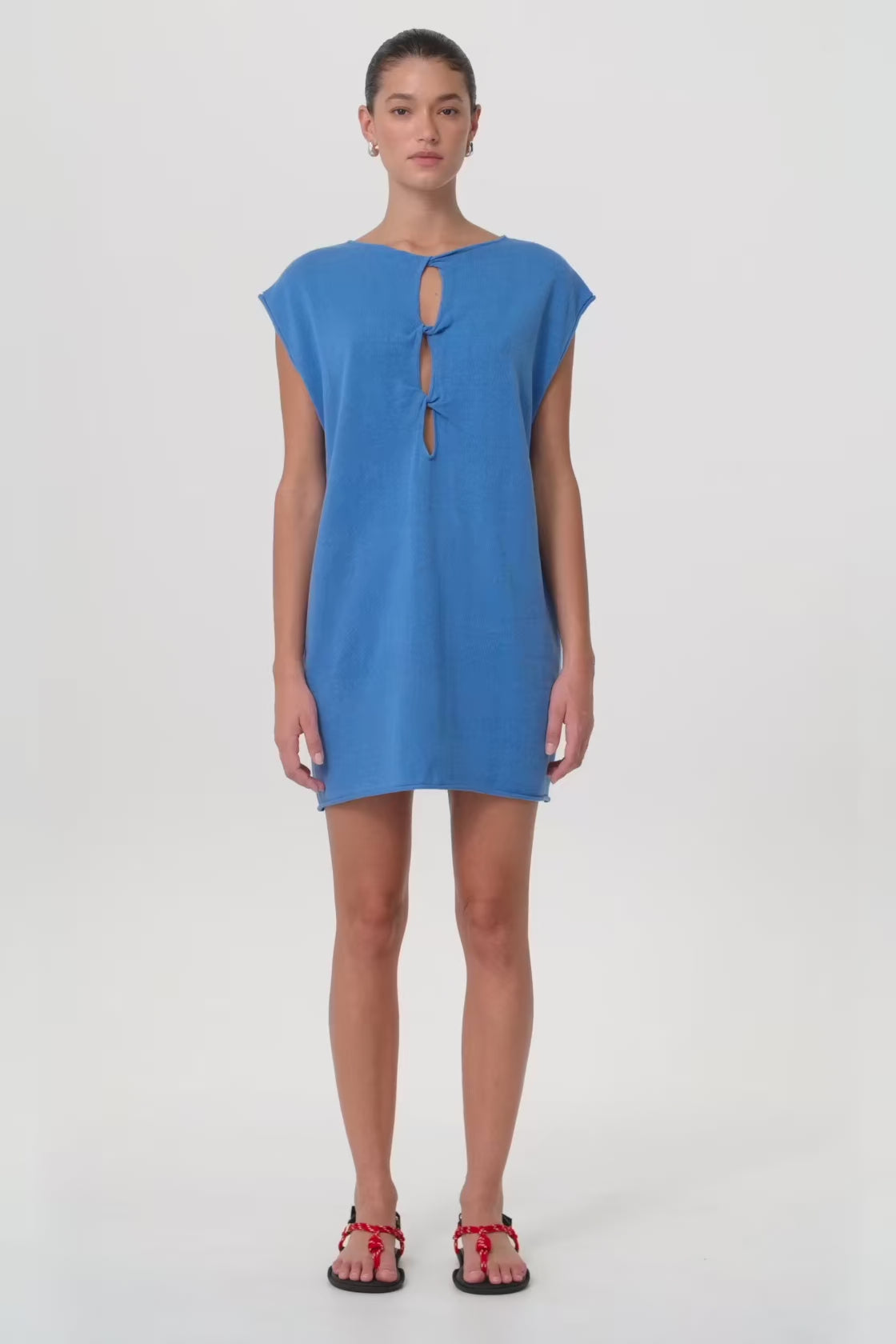 Model in motion wearing reversible shift mini dress with twist detail in pacific blue linen–cotton blend—highlighting soft drape, structure and breathability for seasonal transitions.